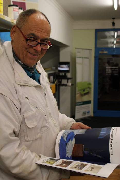 Interior of a paint and color retail shop in Austria, shelves full of paint cans, color swatch wall, clean modern look